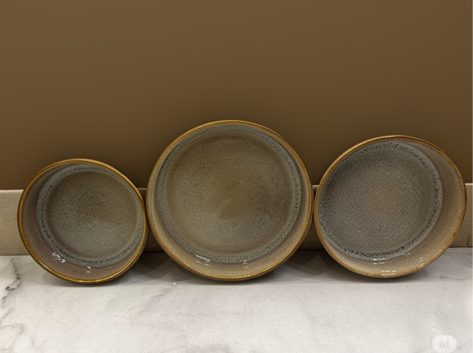 Three ceramic bowls of varying sizes on a marble surface with a brown wall background