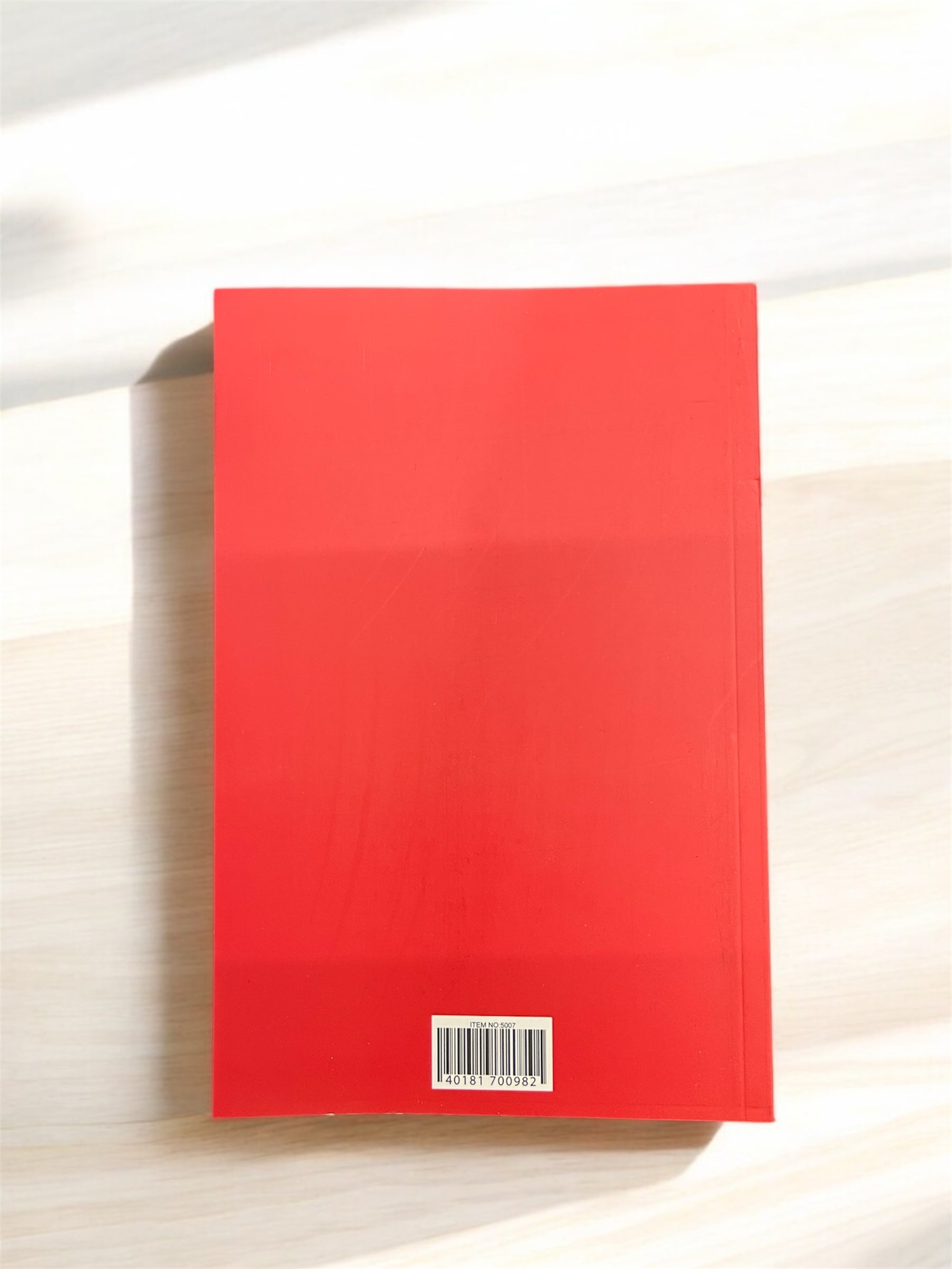 Back cover of Fresh Thoughts cute character A5 journal in bright red on a light wooden surface